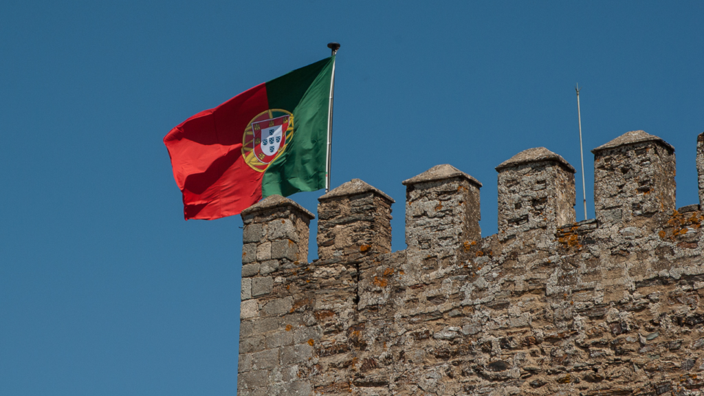 Bandeira de Portugal hasteada em uma construção.